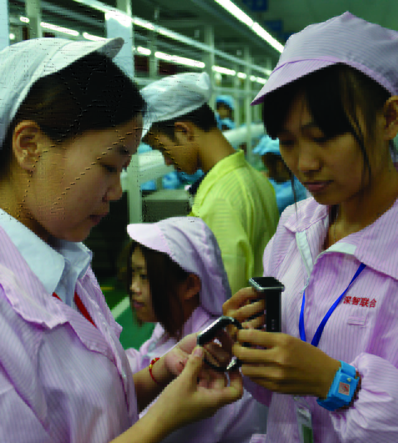 Trabalhadores chineses posam com uma alternativa local mais barata do Relógio Apple em Shenzhen, na província de Guangdong, sul da China, em 22 de abril de 2015 (STR/AFP/Getty Images)