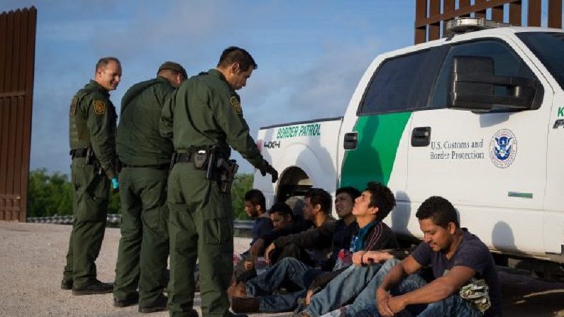 Agentes da Patrulha de Fronteira capturam imigrantes pouco depois de cruzarem ilegalmente a fronteira do México, em 26 de março de 2018 (Loren Elliott/AFP/Getty Images)