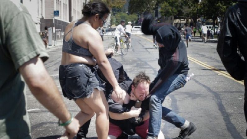 Duas pessoas usando roupas pretas espancaram um homem acusado de ser um defensor de Donald Trump no MLK Jr. Park, em Berkeley na Califórnia, em 27 de agosto de 2017 (Elias Nouvelage/Getty Images)