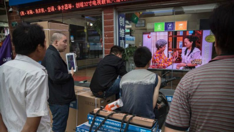 Chineses assistem a um programa de TV pela vitrine de uma loja de eletrodomésticos em Wuhan, província de Hubei, China, em 15 de maio de 2017 (Kevin Frayer/Getty Images)