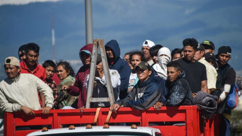 Migrantes de países da América Central — principalmente hondurenhos — viajam em caravana rumo aos Estados Unidos a bordo de um caminhão na rota entre a Cidade do México e Puebla, em 5 de novembro de 2018 (Rodrigo Arangua/AFP/Getty Images)