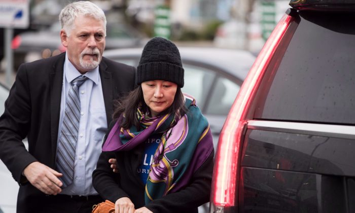 A diretora financeira da Huawei, Meng Wanzhou, chega a um escritório de liberdade condicional com um membro de sua segurança privada em Vancouver, em 12 de dezembro de 2018 (The Canadian Press / Darryl Dyck)