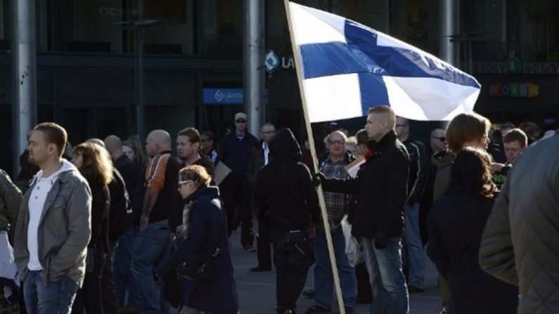 Homem segura bandeira nacional da Finlândia em 3 de outubro de 2015 em Helsinque (Heikki Saukkkomaa/AFP/Getty Images)