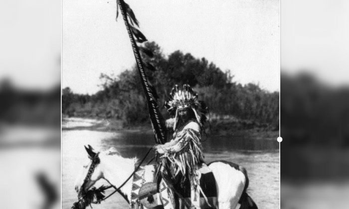 Um chefe da tribo Blackfoot a cavalo e usando trajes e cocar tradicionais, no oeste do Canadá (Coleção Spencer Arnold / Hulton Archive / Getty Images)