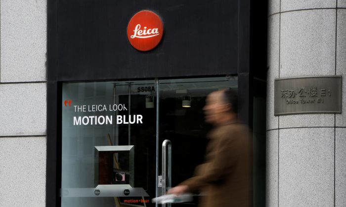 Um homem passa por uma loja de câmeras Leica em Pequim em 19 de abril de 2019 (Thomas Peter / Reuters)