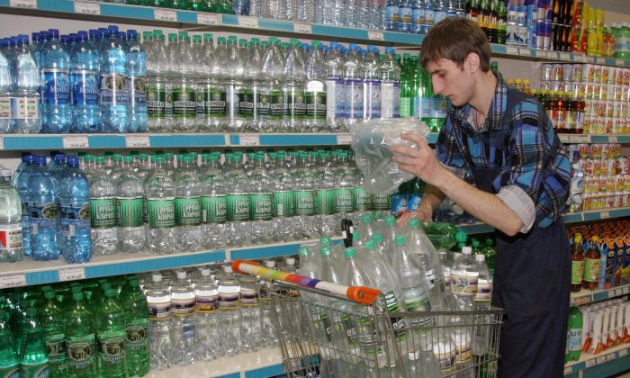 Um empregado empilha garrafas de água em uma loja (Yuri Tutov / AFP / Getty Images)