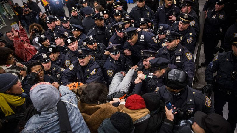 Confronto entre polícia e manifestantes que protestam contra a decisão do Tribunal de Nova Iorque de não acusar um policial envolvido na morte de uma pessoa dentro da estação de metrô do Barclays Center (Foto de Andrew Burton / Getty Images)