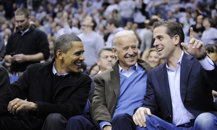 O presidente Barack Obama, à esquerda, conversa com o vice-presidente Joe Biden, no centro, e seu filho Hunter Biden, à direita, no jogo de basquete universitário da Duke Georgetown na NCAA em Washington (AP Photo / Nick Wass)