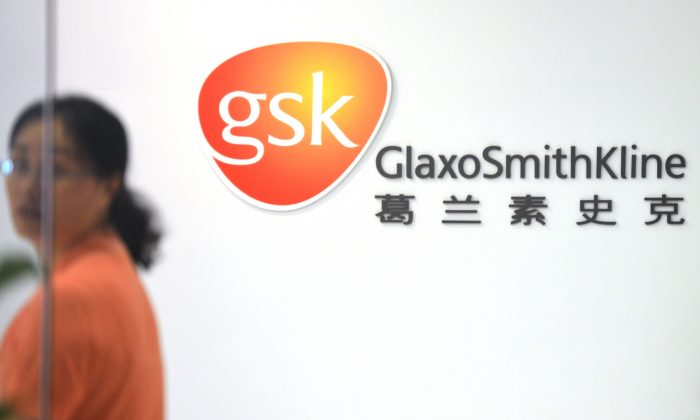 Uma funcinária da empresa farmacêutica britânica GlaxoSmithKline entra na sede do escritório em Xangai no dia 1º de julho (Peter Parks / AFP / Getty Images)