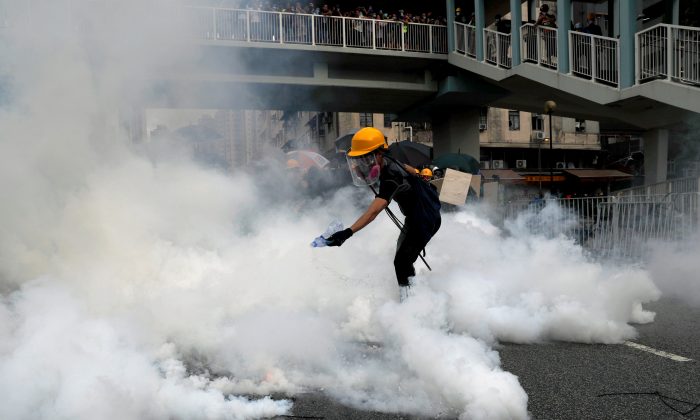 Um manifestante reage a um gás lacrimogêneo durante um protesto contra os ataques da Yuen Long em Yuen Long, Hong Kong, China, em 27 de julho de 2019 (Tyrone Siu / Reuters)