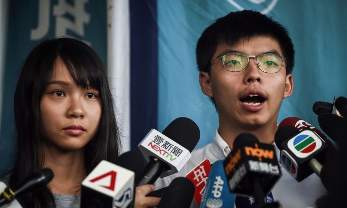 Ativistas pró-democracia Agnes Chow (esquerda) e Joshua Wong (direita) conversam com a imprensa após serem libertados sob fiança nos Tribunais de Magistrados do Leste de Hong Kong em 30 de agosto de 2019 (Lillian Suwanrumpha / AFP / Getty Images)