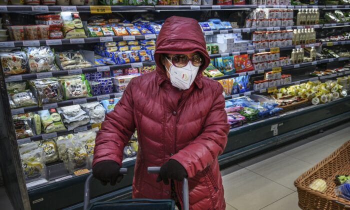 Uma mulher chinesa usa máscara protetora e óculos de sol ao comprar mantimentos em um supermercado em Pequim, China, em 28 de janeiro de 2020 (Kevin Frayer / Getty Images)