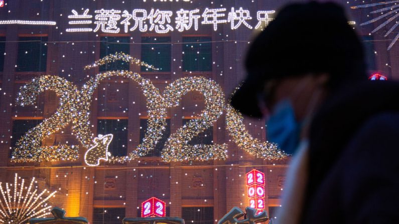 Uma mulher caminha na frente de uma placa de ano novo em Wangfujing em 26 de janeiro de 2020 em Pequim, China. O número de casos de coronavírus aumentou para 1.975 na China continental (Foto de Betsy Joles / Getty Images)