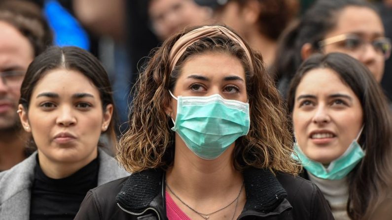 Turistas com máscaras respiratórias protetoras aguardam na Praça de São Pedro, no Vaticano  (Foto de ANDREAS SOLARO / AFP via Getty Images)