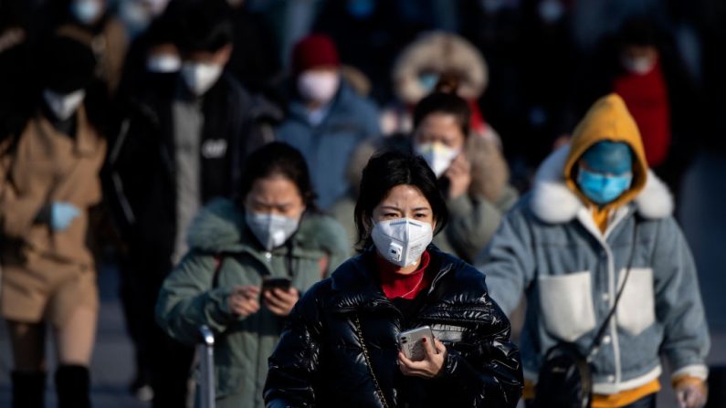 Turistas vindos de várias proíncias usam máscaras faciais ao chegar na estação de trem de Pequim, em 3 de fevereiro de 2020 (NOEL CELIS / AFP / Getty Images)