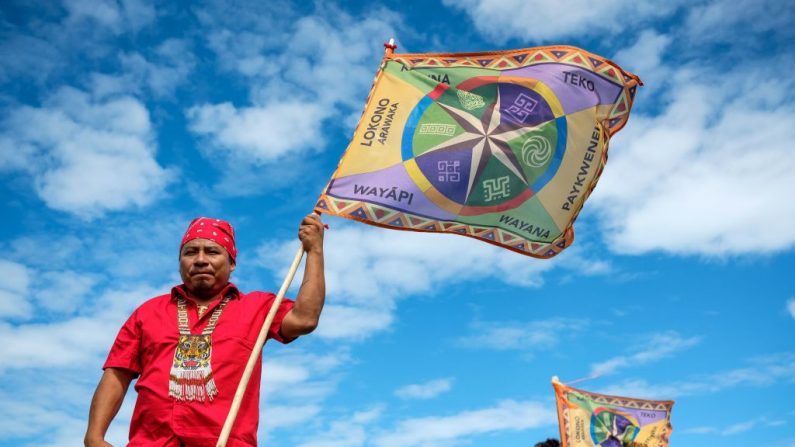 Dois membros da organização Juventude Indígena da Guiana levantam bandeiras durante o Dia Internacional dos Povos Indígenas da Guiana em 9 de agosto de 2018 em Cayenne, Guiana Francesa (Foto por JODY AMIET / AFP via Getty Images)