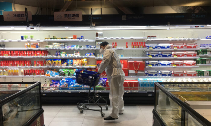 Uma cliente empurra um carrinho enquanto faz compras dentro de um supermercado da rede Hema Fresh da Alibaba, após um surto do novo coronavírus em Wuhan, província de Hubei, China, em 11 de 2020 (Stringer / Reuters)