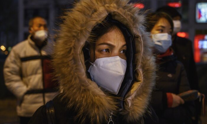 Trabalhadores de escritório chineses usam máscaras protetoras enquanto se alinham no ônibus depois de deixar o trabalho em Pequim, China, em 2 de março de 2020 (Kevin Frayer / Getty Images)