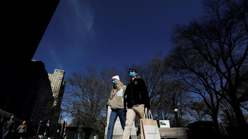 Casal usa máscaras protetoras saindo do Central Park em Nova York, Nova York, EUA, 21 de março de 2020 (EFE / EPA / Peter Foley)