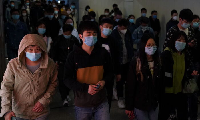 Passageiros transitam com máscaras cirúrgicas em uma estação de metrô durante a hora de pico em Pequim, China, 20 de abril de 2020 (Lintao Zhang / Getty Images)