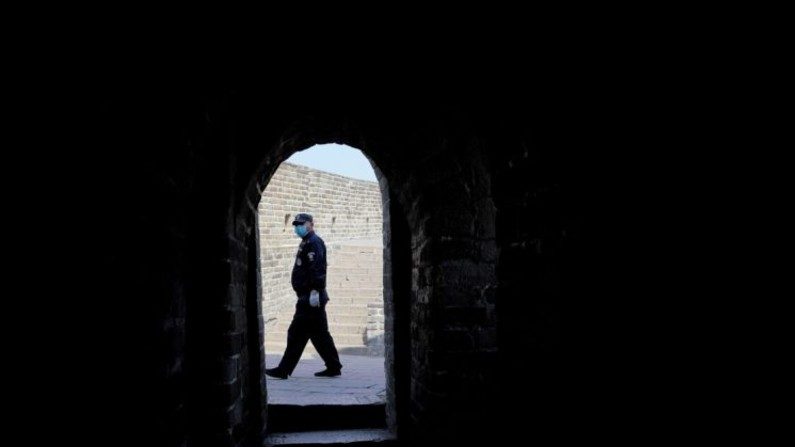 Um guarda de segurança usa uma máscara protetora na Grande Muralha de Badaling, quase vazia, em Pequim, China, em 24 de março de 2020 (Lintao Zhang / Getty Images)