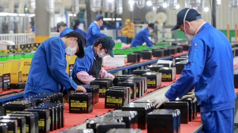 Funcionários trabalham em uma linha de produção de baterias em uma fábrica em Huaibei, província de Anhui, leste da China, em 30 de março de 2020 (STR / AFP via Getty Images)