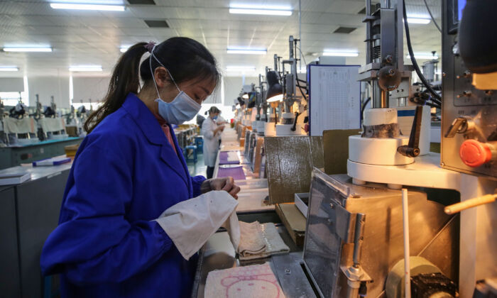 Trabalhadora em uma linha de produção fotoelétrica em uma fábrica em Wuhan, China, em 6 de abril de 2020 (STR / AFP via Getty Images)