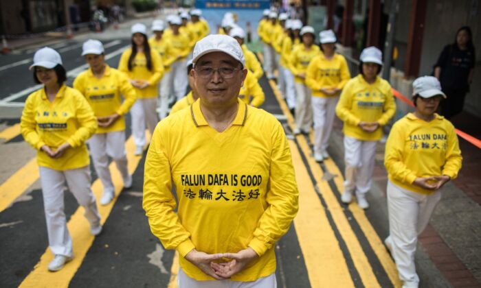 Praticantes da disciplina espiritual do Falun Gong participam de uma marcha em Hong Kong em 27 de abril de 2019 (DALE DE LA REY / AFP via Getty Images)