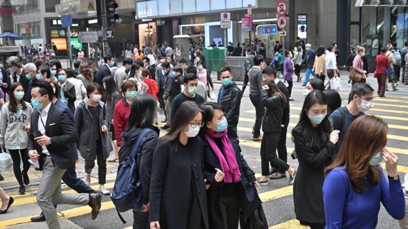 Pedestres com máscaras faciais em Hong Kong em 12 de março de 2020 (Antony Wallace / AFP via Getty Images)