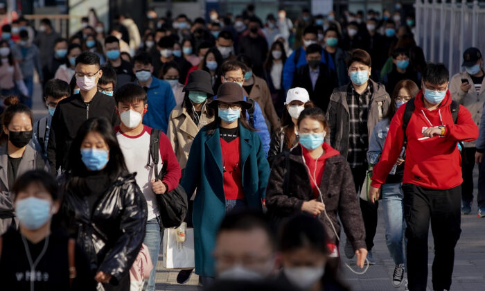 Passageiros usam máscaras protetoras ao sair de um trem em uma estação de metrô na hora do rush na segunda-feira, 13 de abril de 2020 em Pequim, China (Lintao Zhang / Getty Images) 