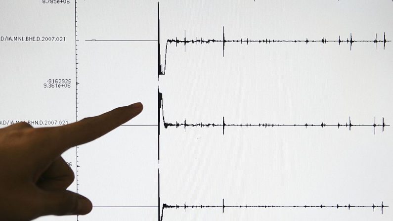 Um oficial da Agência de Meteorologia e Geofísica (BMG) aponta para um gráfico no escritório do BMG de um terremoto de magnitude 6,5 que atingiu a província de North Sulawesi em 21 de janeiro de 2007 na ilha de Sulawesi, na Indonésia (Foto de Dimas Ardian / Getty Images)