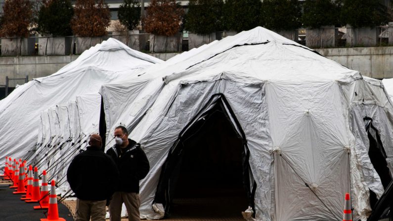 As pessoas falam perto de um necrotério improvisado fora do Hospital Bellevue em 25 de março de 2020 na cidade de Nova York, Nova York (Foto de Eduardo Munoz Alvarez / Getty Images)