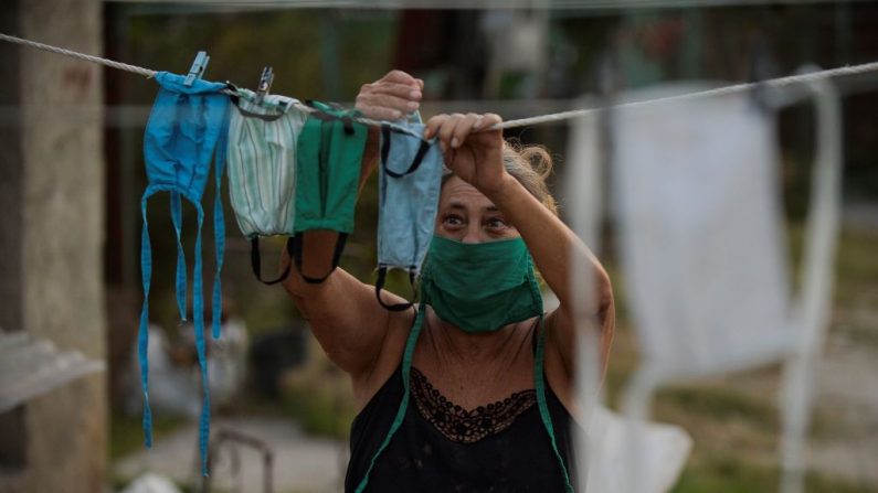 Uma mulher pendura máscaras faciais depois de lavá-las em sua casa no município de Mariel, em Artemisa, Cuba, em 23 de abril de 2020 (YAMIL LAGE / AFP via Getty Images)