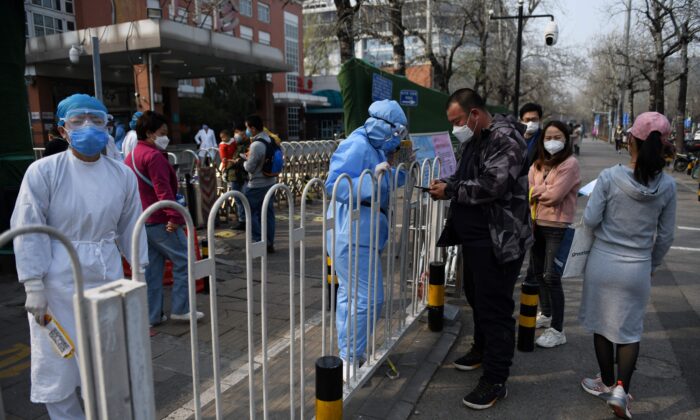 Uma equipe hospitalar (esquerda) registra pacientes na calçada do lado de fora de um hospital infantil em Pequim, China, em 31 de março de 2020 (GREG BAKER / AFP via Getty Images)