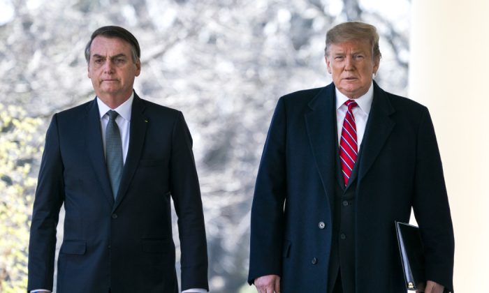 O presidente dos EUA, Donald Trump (direita), e o presidente do Brasil, Jair Bolsonaro (esquerda), caminham pela Colunata antes de uma conferência de imprensa no Jardim de Rosas da Casa Branca, em Washington, DC, em 19 de março de 2019