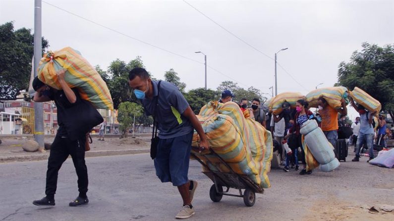 Cidadãos venezuelanos levam seus pertences de volta ao país nesta quinta-feira em Cúcuta (Colômbia). O desejo de milhares de venezuelanos de retornar ao seu país devido à pandemia do COVID-19, que os deixou sem oportunidades de emprego na Colômbia, tornou-se uma odisséia para famílias inteiras que diariamente encontram todos os tipos de obstáculos para alcançar para a fronteira (EFE / Alex Pérez)