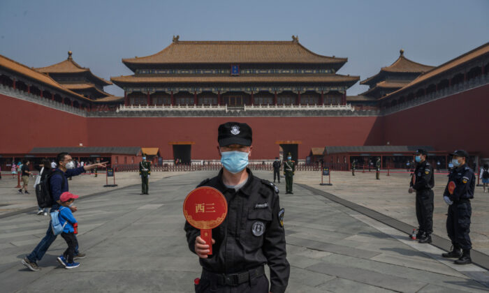 Um guarda chinês usa uma máscara protetora em pé na entrada da Cidade Proibida, em Pequim, China, em 1 de maio de 2020, aberta a visitantes limitados (Kevin Frayer / Getty Images)