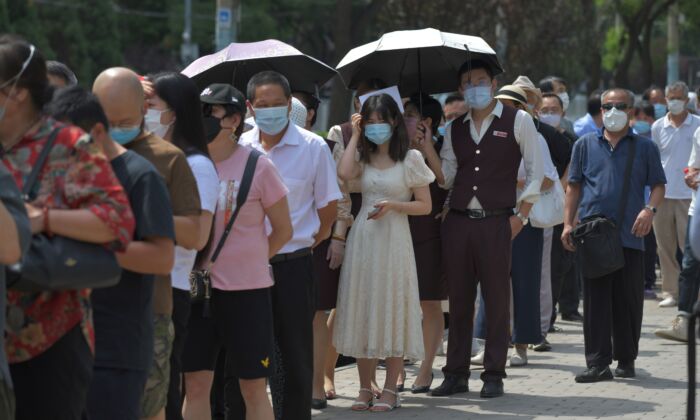 Pessoas aguardam na fila para realizar os testes de COVID-19 em uma estação de testes em Pequim, China, em 30 de junho de 2020 (GREG BAKER / AFP via Getty Images)