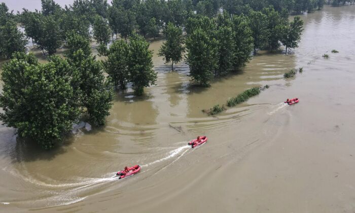 Bombeiros estão patrulhando barcos em uma área inundada perto do rio Yangtze em Zhenjiang, na província de Jiangsu, leste da China, em 20 de julho de 2020 (STR / AFP via Getty Images)