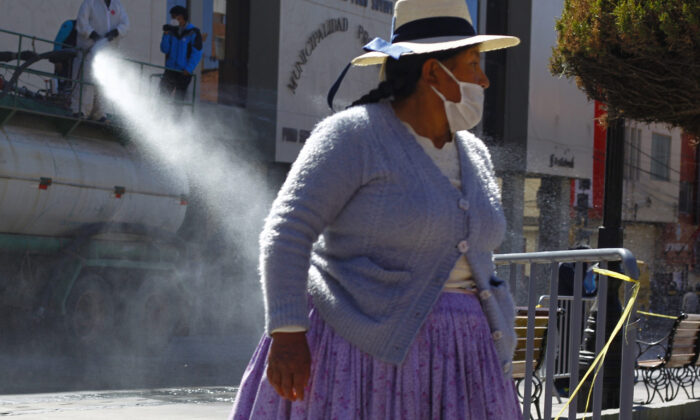 Diante da pandemia de COVID-19, trabalhadores municipais desinfetam as principais ruas de Puno, no planalto peruano, perto da fronteira com a Bolívia, em 17 de julho de 2020 (CARLOS MAMANI / AFP via Getty Images)