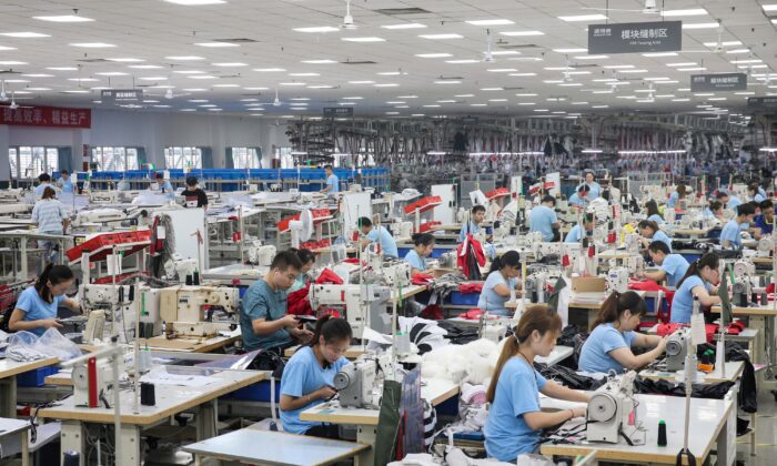 Funcionários produzem casacos em uma fábrica para a empresa de roupas chinesa Bosideng em Nantong, província de Jiangsu oriental, em 24 de setembro de 2019 (STR / AFP via Getty Images)