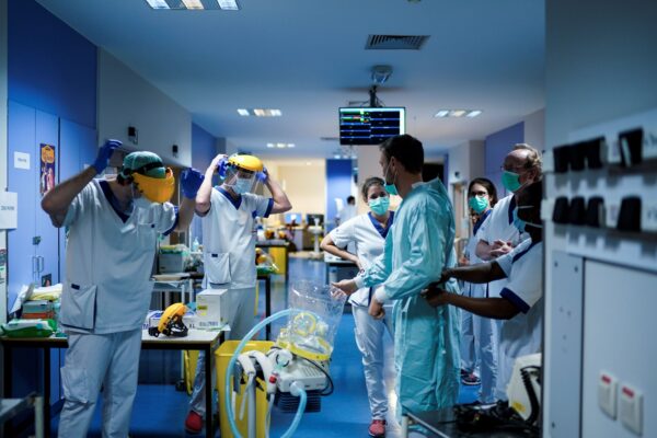 Vários profissionais de saúde vestem equipamento de proteção antes de trabalhar na unidade para pacientes infectados com COVID-19 no Hospital Erasme em Bruxelas em 27 de março de 2020 (Kenzo Tribouillard / AFP via Getty Images)