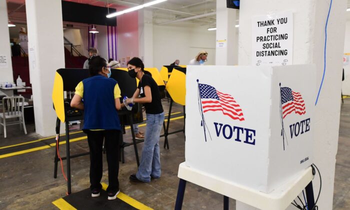 Um eleitor recebe assistência de um trabalhador eleitoral em um centro de votação no Grand Central Market em Los Angeles, Califórnia, em 3 de novembro de 2020 (Frederic J. Brown / AFP via Getty Images)
