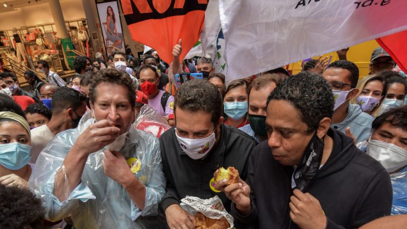 Sao Paulo's mayoral candidate for the Socialism and Freedom Party (PSOL), Guilherme Boulos (C), campaigns along with defeated candidates Jilmar Tatto (L) of the Workers' Party (PT) and Orlando Silva, of the Communist Party of Brazil (PCdoB), during a rally in Sao Paulo downtown, Brazil, on November 18, 2020. - The Brazilian municipal runoff election will take place on November 29. Left-wing candidate Guilherme Boulos won on November 15 a surprise pass to the second round, where he will face current Mayor Bruno Covas. (Photo by Nelson ALMEIDA / AFP) (Photo by NELSON ALMEIDA/AFP via Getty Images)