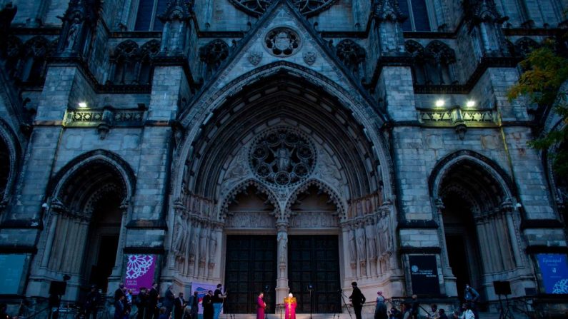 Pessoas participam de uma vigília à luz de velas em uma procissão em homenagem a todas as vidas afetadas pelo coronavírus, em frente à Catedral de São João, o Divino, em 19 de outubro de 2020, na cidade de Nova Iorque (Foto por KENA BETANCUR / AFP via Getty Images)