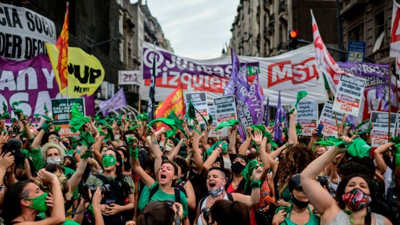 Manifestantes comemoram com lenço de cabeça verde - o símbolo dos ativistas pelos direitos do aborto - fora do Congresso Argentino em Buenos Aires em 11 de dezembro de 2020, depois que os legisladores aprovaram um projeto de lei para legalizar o aborto (Foto de RONALDO SCHEMIDT / AFP via Getty Images)