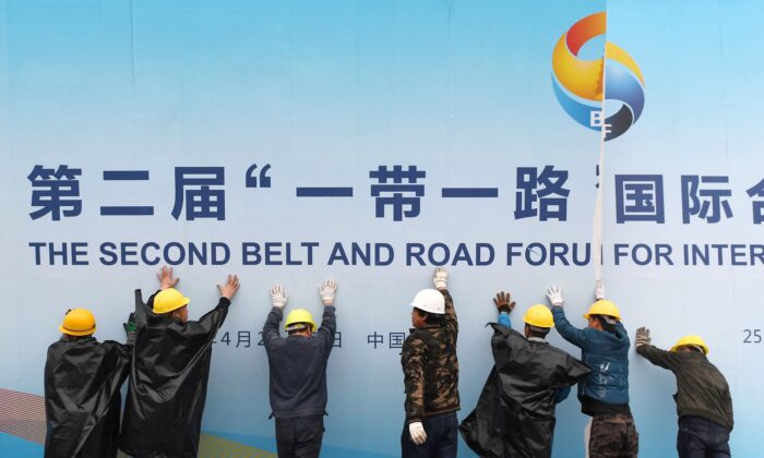 Trabalhadores retiram um painel do Forum 'Um cinturão, uma rota' fora em Pequim em 27 de abril de 2019. (Greg Baker / AFP via Getty Images)
