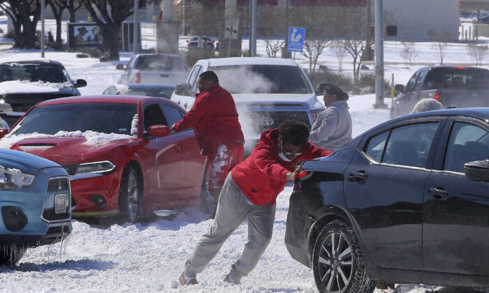 As pessoas soltam um carro depois de rodopiar na neve em Waco, Texas, em 15 de fevereiro de 2021 (Jerry Larson / Waco Tribune-Herald via AP)
