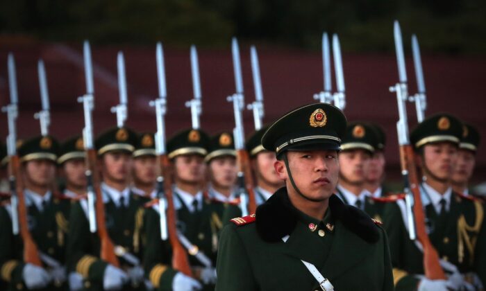 Um policial paramilitar monta guarda durante a cerimônia de abaixamento da bandeira na Praça Tiananmen, em Pequim, em 13 de novembro de 2012 (Feng Li / Getty Images)