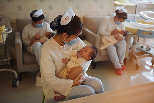 Enfermeiras seguram bebês no Xiyuege Center, ou "Lucky Month Home", em Pequim em 13 de dezembro de 2016 (Greg Baker / AFP via Getty Images)
